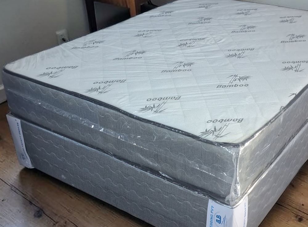 Bamboo spring double bed with a white bamboo-print mattress on a grey base in a bedroom