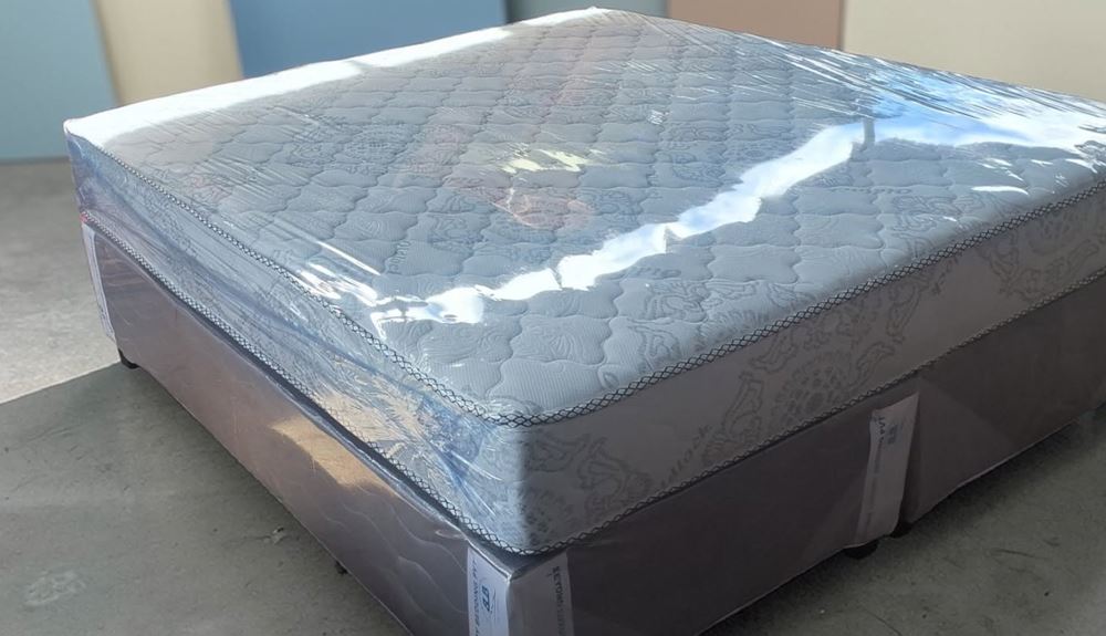 10-inch compressed foam king bed in protective wrap on a two-part grey base